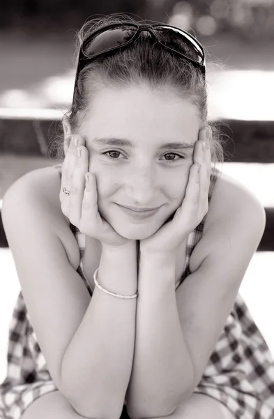 Портрет милой девочки-подростка, сидящей на скамейке — стоковое фото
