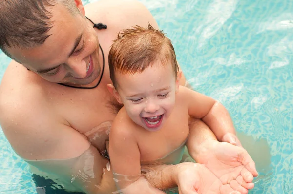 Baba ve oğlu eğlenceli yüzme havuzunda güzel yaz günü sahip. — Stok fotoğraf
