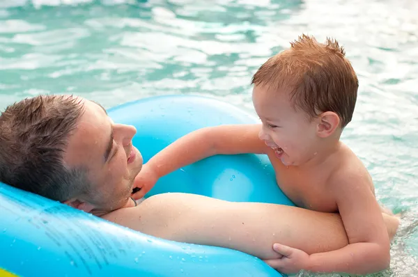 Baba ve oğlu eğlenceli yüzme havuzunda güzel yaz günü sahip. — Stok fotoğraf