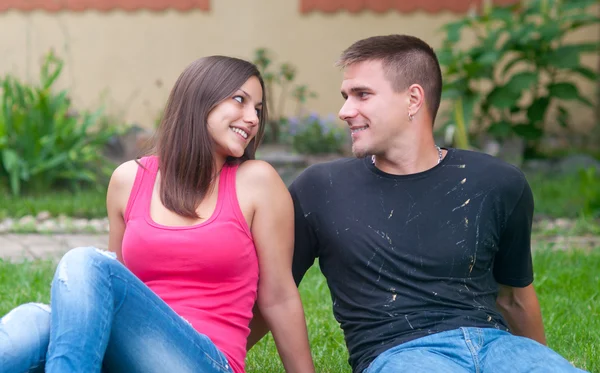 Güzel genç mutlu çifti onların bahçesinde oturan — Stok fotoğraf