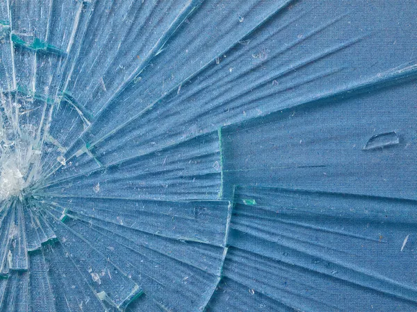 Ραγισμένο γυαλί μακροεντολή με ένα μπλε φόντο με σχέδια — Φωτογραφία Αρχείου