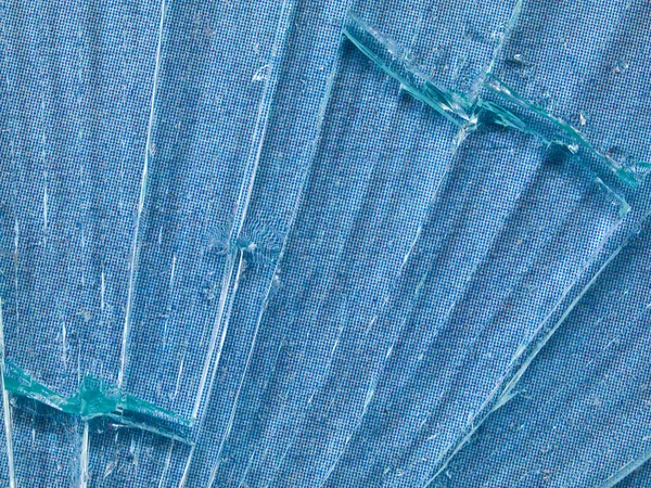 Тріснуте скляне макрос з фоном блакитного візерунка — стокове фото