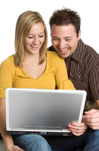Sonriendo, pareja joven navegando por Internet en una computadora portátil — Foto de Stock