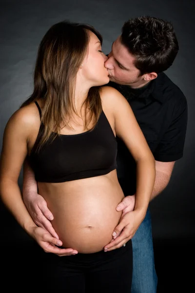 Беременная пара целуется — стоковое фото