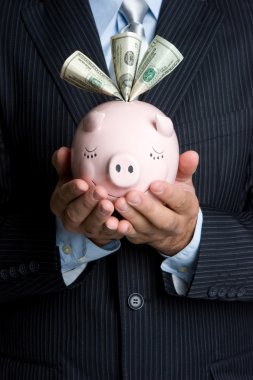 Businessman Holding Piggy Bank clipart