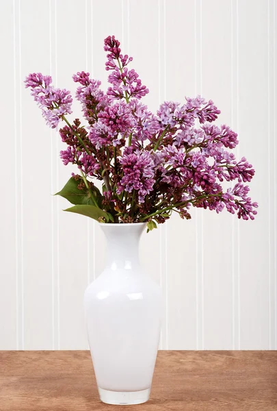 Weiße Vase mit lila Blüten — Stockfoto