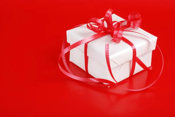 Fehér karácsonyi ajándék piros szalaggal — Stock Fotó