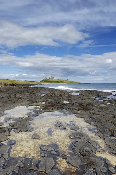 Dunstanburgh Castle and rockpool — Stock Photo, Image
