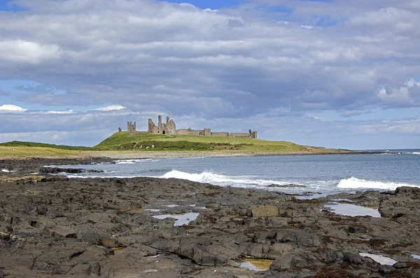 Craster kasteel kust met golven — Stockfoto