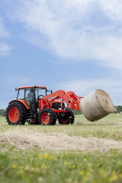 Traktor dragande round bale — Stockfoto