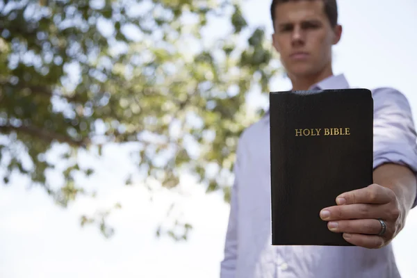 Человек держит Библию — стоковое фото