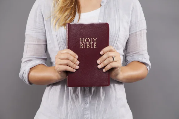 Ung kvinna håller rödbruna Bibeln — Stockfoto