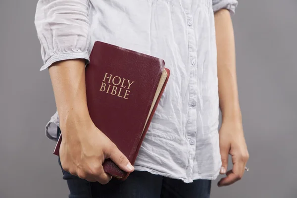 Kvinnan håller Bibeln på sin sida — Stockfoto