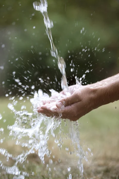 Profil rukou chytat střik vody — Stock fotografie