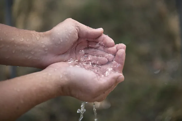 L'eau ruisselante entre les mains — Photo