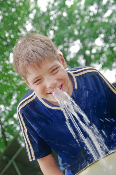 Ragazzo che beve acqua con un sorriso — Foto Stock