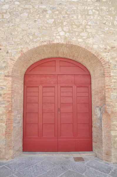 Porta de madeira e uma parede de pedra — Fotografia de Stock