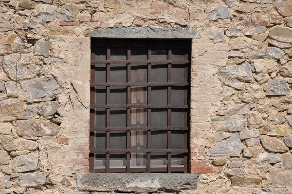 Steel grid and window in stone wall — Stock Photo, Image