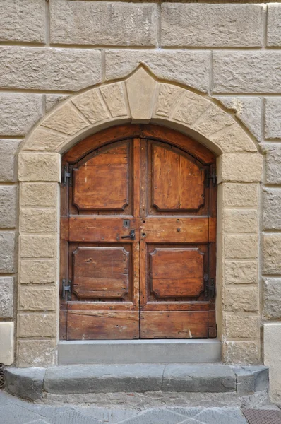 Puerta de madera y un muro de piedra, edificios Toscana — Foto de Stock