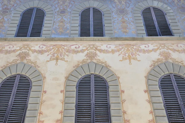 Барвистий фасад будинку з закритими віконницями — стокове фото