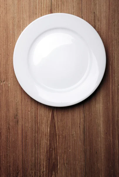 Prázdný bílý talíř na dřevěném stole — Stock fotografie