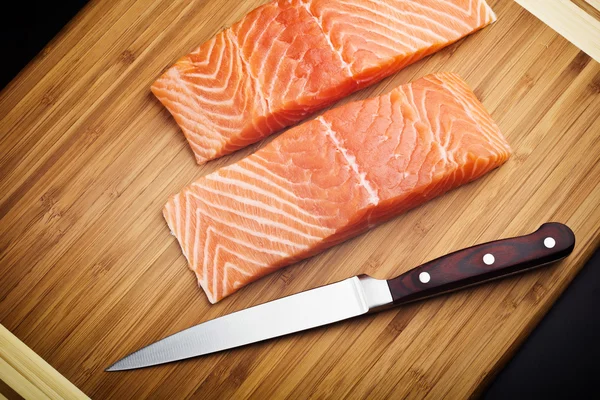 Filé de salmão com faca na placa de madeira — Fotografia de Stock