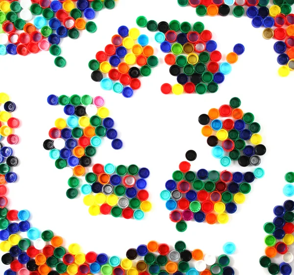 Переработка символа из цветных пластиковых колпачков — стоковое фото