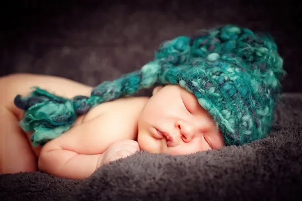 Pasgeboren baby (op de leeftijd van 7 dagen) in een gebreide gestreepte muts — Stockfoto