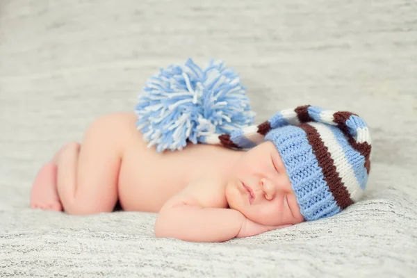 Slapende babyboy draagt een gestreepte hoed — Stockfoto