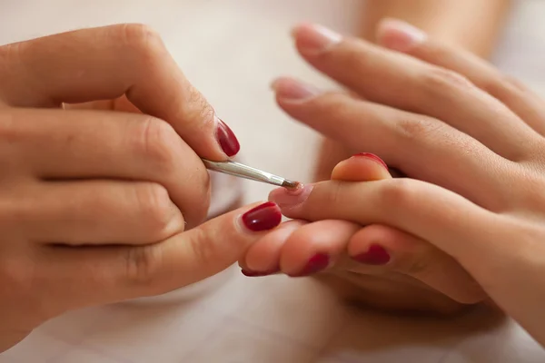 Manicure making - female hands, covering of transparent enamel, — Stock Photo, Image