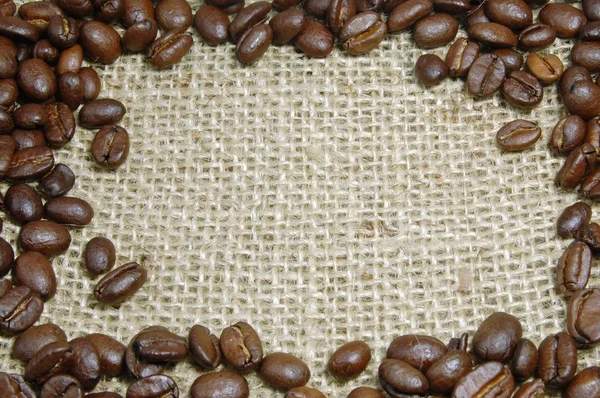 Kávová zrna na pytlovina — Stock fotografie