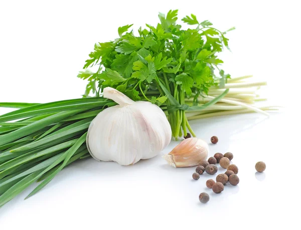 Spring greenery is with a garlic and grains of pepper on a white background — Stock Photo, Image