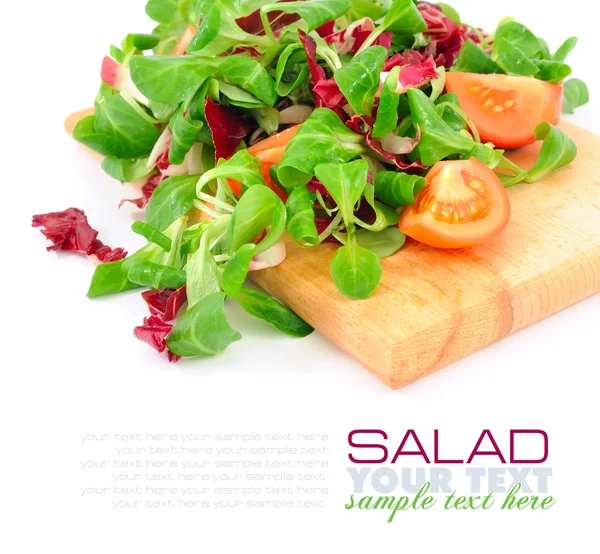 Salada mista fresca com tomates em uma tábua de madeira — Fotografia de Stock