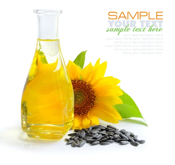 Подсолнечное масло с цветами и семенами на белом фоне — стоковое фото