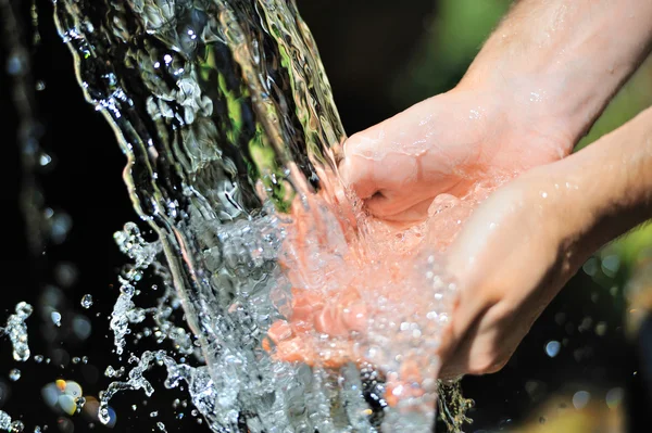 Žena ruce s stříkající vodě — Stock fotografie