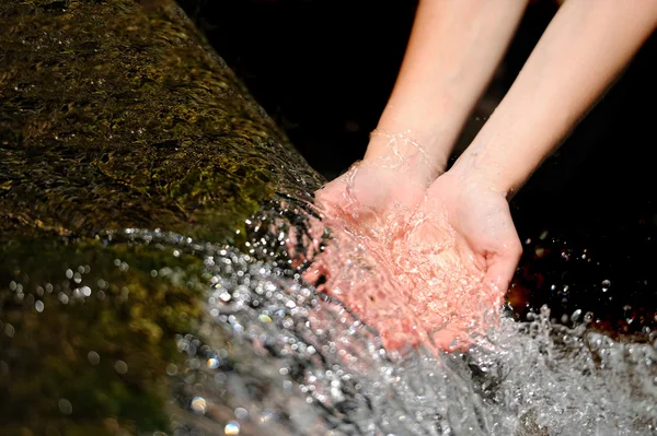 Manos de mujer con agua salpicada — Foto de Stock