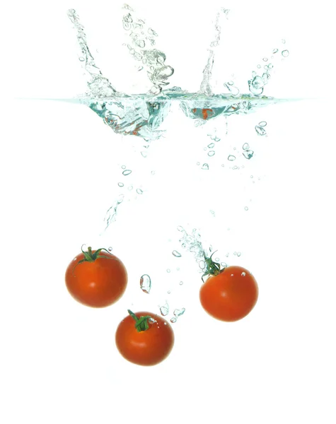 Drei Tomaten fallen ins Wasser — Stockfoto