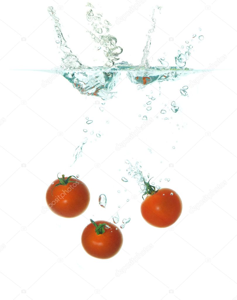Three tomatoes falling in water