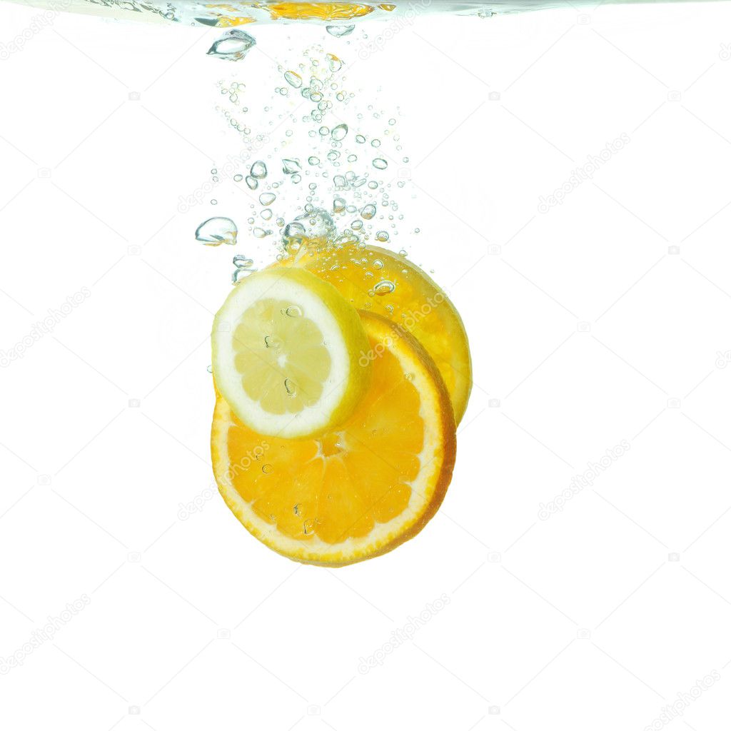Slices of citrus fruit falling in water