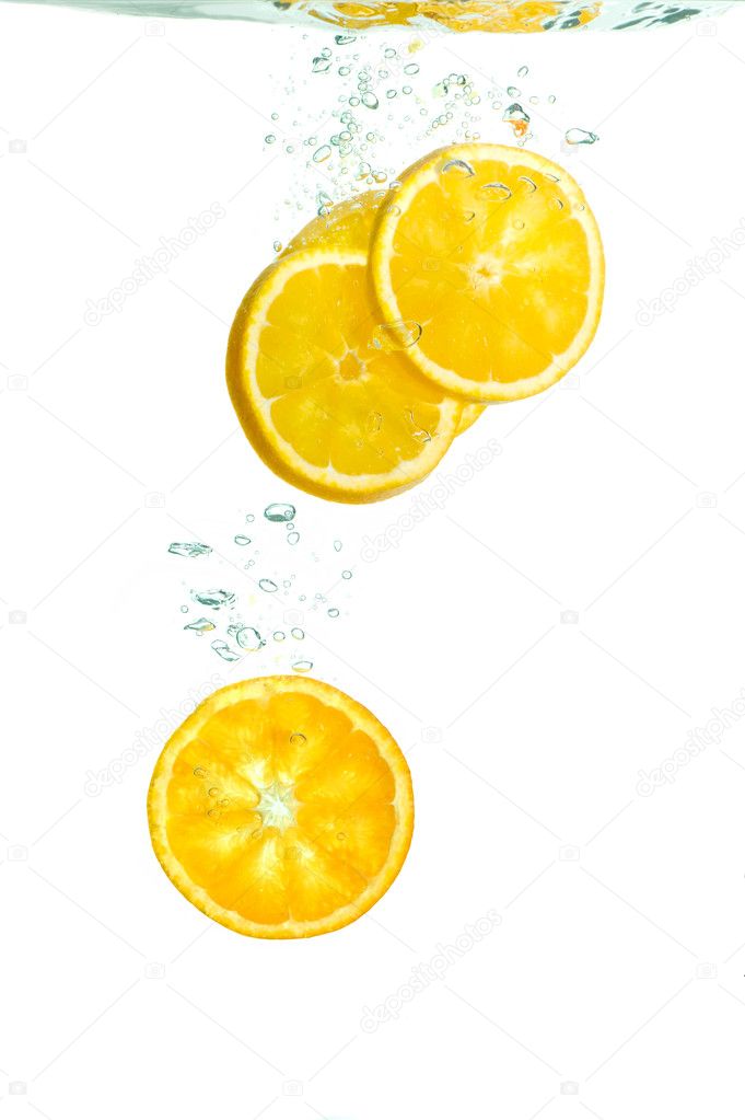 Orange slices falling in water