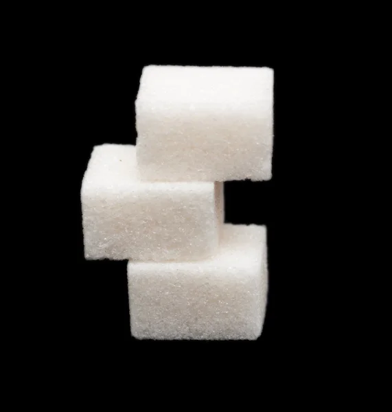 Drei Zuckerklumpen auf schwarzem Hintergrund — Stockfoto