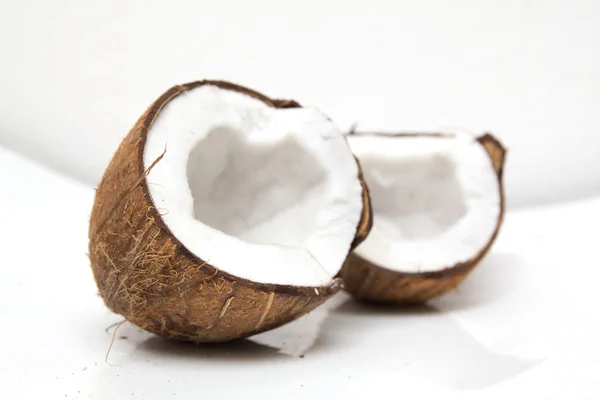 Closeup de coco rachado no fundo branco com sombra clara — Fotografia de Stock