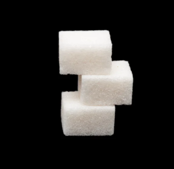 Tři kostky cukru na černém pozadí — Stock fotografie