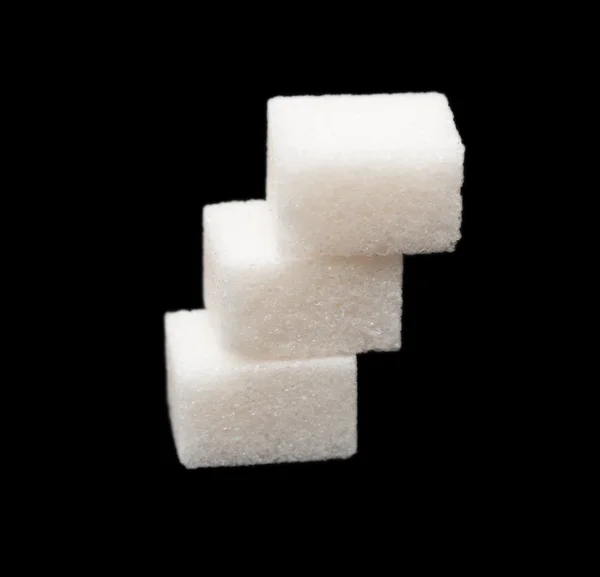 Drie brokken van suiker op een zwarte achtergrond — Stockfoto
