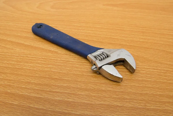 Blue monkey wrench on a wooden background — Stock Photo, Image