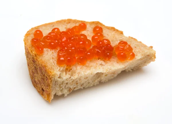 Красная икра крупным планом на хлебе на белом фоне — стоковое фото
