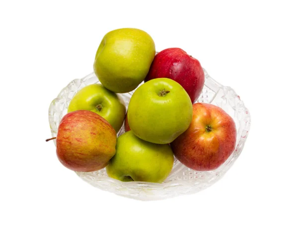 Зеленые и красные яблоки в хрустальной тарелке на белом фоне — стоковое фото