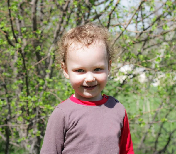 Улыбающийся мальчик на зеленом фоне — стоковое фото