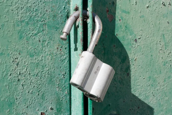 Big padlock on a green metal gate — Stock Photo, Image