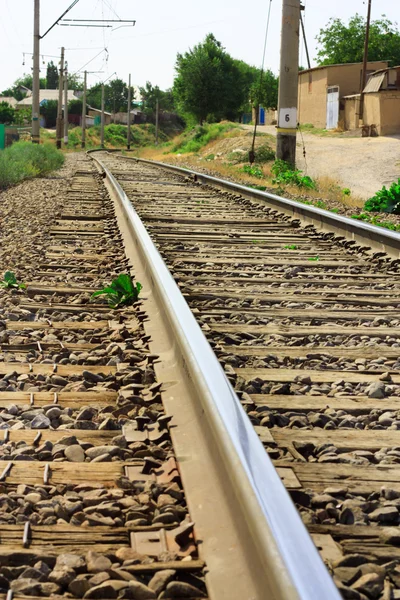 Railroad tracks verdwijnen in een bosrijke omgeving — Stockfoto